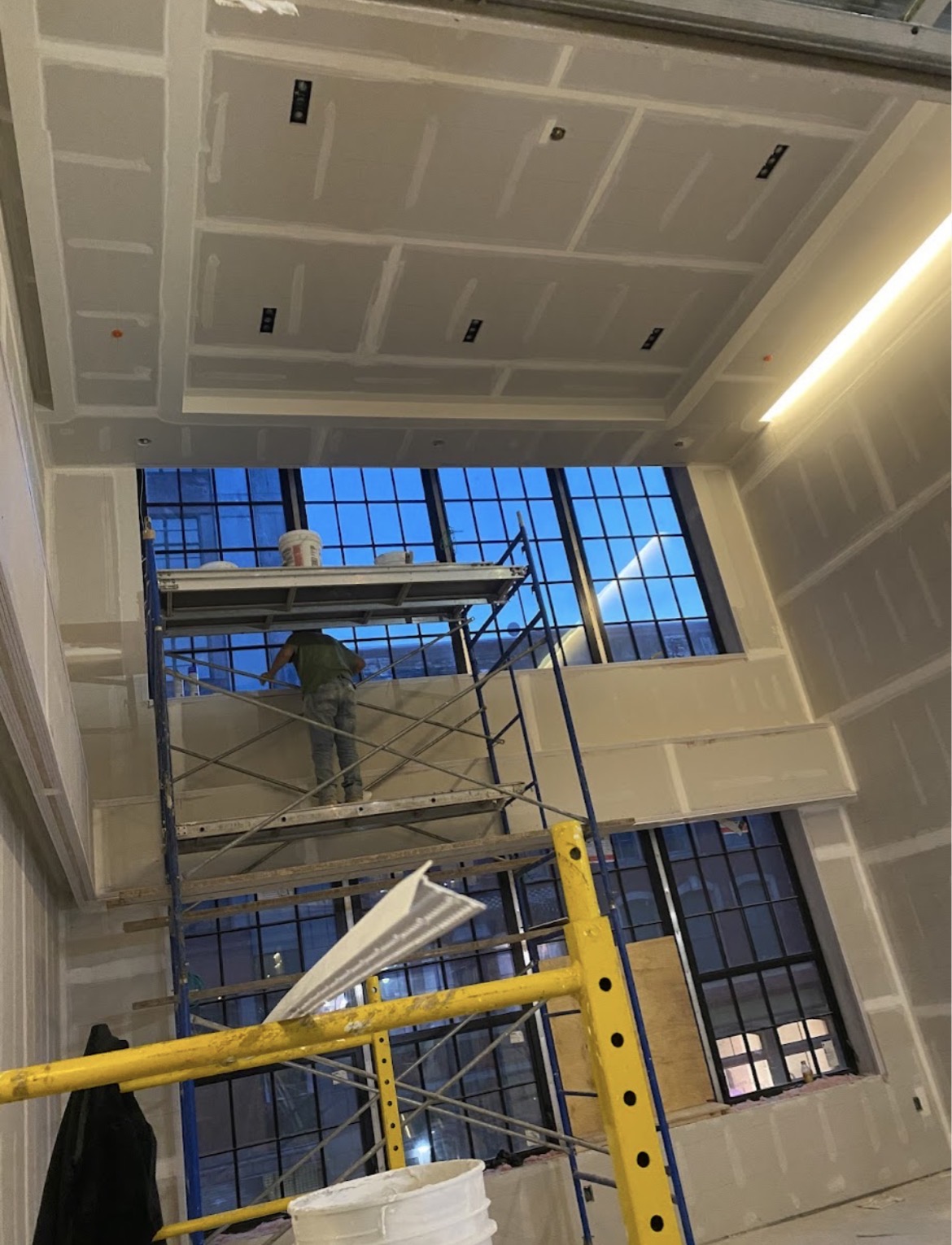 High-ceiling commercial drywall near floor-to-ceiling windows